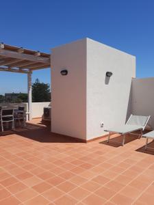 a building with a table and chairs on a patio at Casa Nettuno Favignana in Favignana