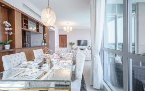 a dining room with a glass table and white chairs at Elite Royal Apartment - Full Burj Khalifa & Fountain View - Premier - 2 bedrooms & 1 open bedroom without partition in Dubai