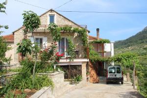 une maison avec une voiture garée devant elle dans l'établissement Apartmani Ivanković, à Vrisnik