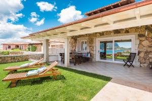 Casa de piedra con patio con mesa y sillas en S'Abba e Sa Pedra, en Golfo Aranci