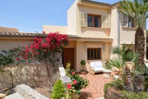 une maison avec des fleurs et des plantes dans une cour dans l'établissement Sa casa des Padrino, à Santa Ponsa