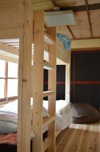 a wooden bunk bed in a room with a bed at Satoyama Guest House Couture in Ayabe