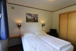 a bedroom with a white bed and two lamps at UplandParcs Dumel - gemütliches Haus in zentrumsnähe in Winterberg