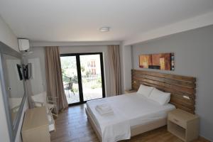 a bedroom with a white bed and a large window at Sivota Muses in Syvota