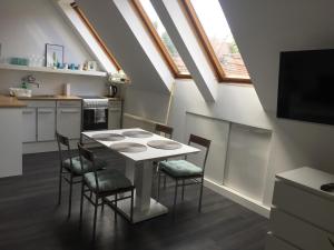 a kitchen with a table and chairs in a room at Rozmaring Apartman Pécs in Pécs