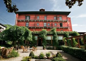 ein rotes Gebäude mit einem Tisch und Stühlen davor in der Unterkunft Churrut Hotel in Bera