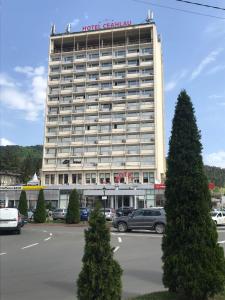 a hotel building with cars parked in a parking lot at Sarah Apartments in Piatra Neamţ