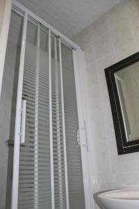 a bathroom with a window with blinds on it at Hotel The Originals du Grand Monarque Nantes Gare in Nantes