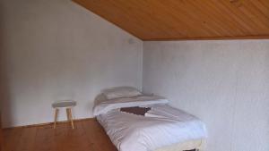 ein kleines Schlafzimmer mit einem Bett und einem Stuhl in der Unterkunft Holiday Home Nana in Bugojno