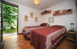 a bedroom with two beds and a large window at Bellavista Cascianella in Piazza al Serchio