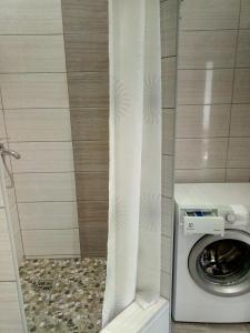 y baño con ducha y lavadora. en Apartment complex Parklend, en Kiev