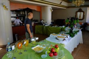 Un homme debout à côté de deux tables avec de la nourriture sur elles dans l'établissement Hotel Eden By Bluebay, à Oruro