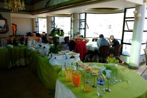 een eetkamer met groene tafels met eten erop bij Hotel Eden By Bluebay in Oruro