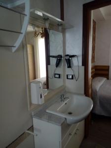 baño con lavabo, espejo y cama en B&B DA DILETTA, en Rieti