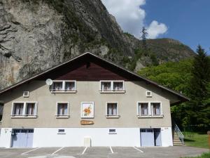 a building in front of a mountain at Les Lys Orangés in Le Bourg-dʼOisans