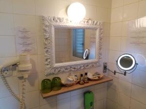 a bathroom with a mirror and a phone on the wall at Guest House Vila Luka in Portorož