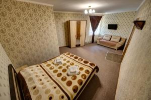 pokój hotelowy z łóżkiem i kanapą w obiekcie Villa Vlad & Spa w mieście Bukowel