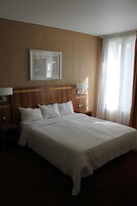 Кровать или кровати в номере Hotel The Originals du Grand Monarque Nantes Gare