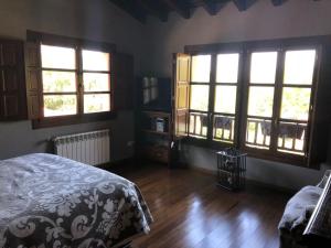 a bedroom with two windows and a bed and wooden floors at Lugar Meluerda in Meluerda +114 photos