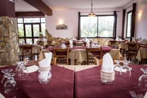 una sala da pranzo con tavoli e tovaglioli bianchi di B&B Il Ristoro del Viandante a Caulonia