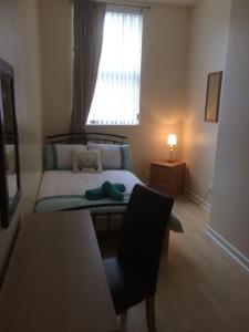 a small bedroom with a bed and a window at MARLEY MANSIONs APARTMENTS - KING ST REF : 10/3 in Wallasey