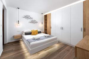 a bedroom with a large bed with white cabinets at Lindos Heart Apartments in Líndos