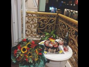 Una mesa con una botella de champán y flores. en Carita Hotel en Dalat