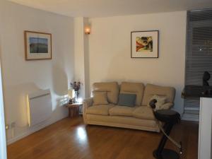 ein Wohnzimmer mit einem Sofa und einem Tisch in der Unterkunft Rotherhithe apartment near park and river in London
