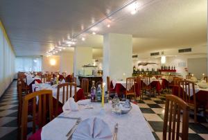 a dining room with tables and chairs in a restaurant at Hotel Carlton in Lignano Sabbiadoro