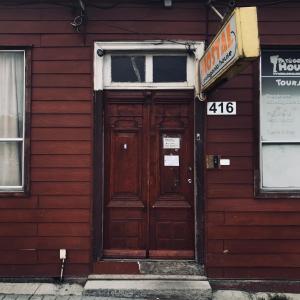 a wooden door on a red building with a sign at Patagonia House in Punta Arenas +17 photos