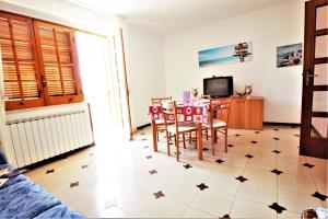 a living room with a table and chairs and a tv at holidaycasa Leone - Con posto auto a 200mt dal Mare in Sperlonga