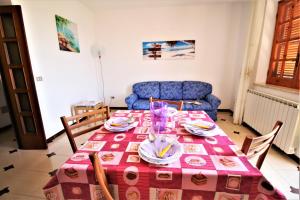 a dining room table with a red and white table cloth at holidaycasa Leone - Con posto auto a 200mt dal Mare in Sperlonga