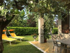 un groupe de chaises assises sous un arbre dans l'établissement Casa Mary due - trilocale con giardino privato a due passi dal lago, à Sirmione