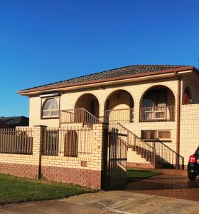 a brick house with a fence in front of it at Adelaide's holiday home in Modbury
