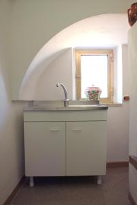 a kitchen with a sink and a window at Il Trullo di Nonna Enza in Castellana Grotte