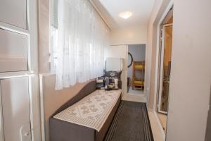 a small room with a bed and a window at Valentina Apartman in Petrovac na Moru