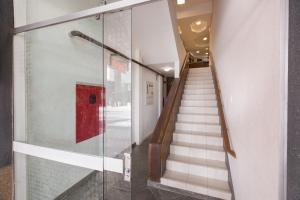 una escalera con puerta de cristal en un edificio en Brasil Express, en Balneário Camboriú