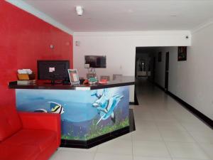 a living room with a red couch and an aquarium at Ayenda Hotel Muleke in Santa Marta