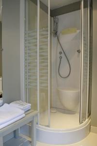 La salle de bains est pourvue d'une cabine de douche et d'un lavabo. dans l'établissement Hôtel Les Chevaliers, à Laon