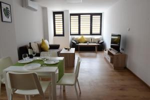a living room with a table and chairs and a television at Hotel Active Apartments in Targovishte
