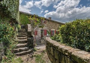 ein Steinhaus mit einer Steinmauer und einer Treppe in der Unterkunft L'Oustau de Pequeti in Laboule
