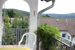 einen Balkon mit einem Tisch und einem weißen Stuhl in der Unterkunft Ferienwohnungen Angela in Bad Marienberg