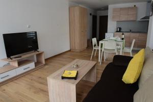 a living room with a couch and a tv and a table at Hotel Active Apartments in Targovishte