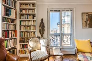 a living room with book shelves filled with books at Veeve - Classic Montparnasse in Paris