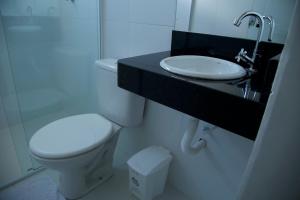 um banheiro com um vaso sanitário branco e uma pia em Hotel Macapaba em Macapá mais 26 fotografias