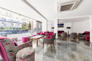 a waiting room with pink chairs and a table at Hotel Santo António de Pádua in Fátima
