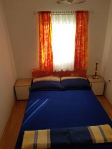 a bedroom with a blue bed and a window at Apartment Nera in Ledenice