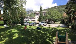a yard with a swing set in the grass at Casa Vittoria in Nago-Torbole