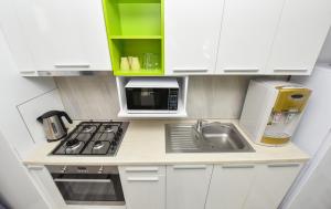 a small kitchen with a sink and a microwave at Dreamtime Apartments in Bucharest