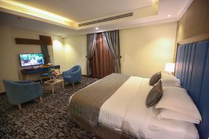 una camera d'albergo con un letto e una televisione di Le Park Concord Hotel Al Majmaah a Al Majmaah